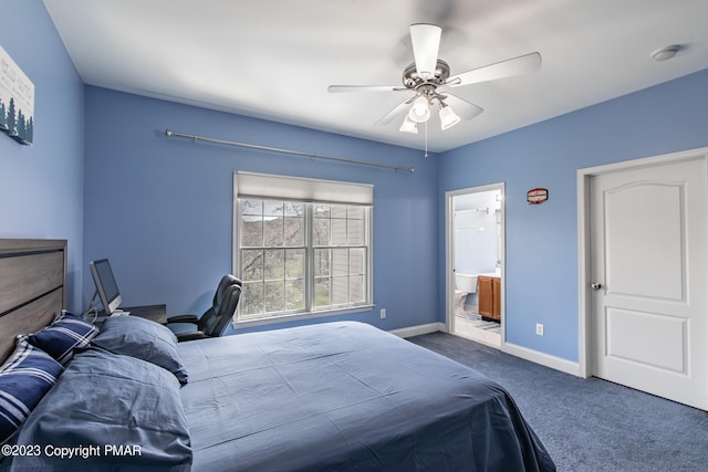 bedroom with baseboards, dark colored carpet, a ceiling fan, and ensuite bathroom