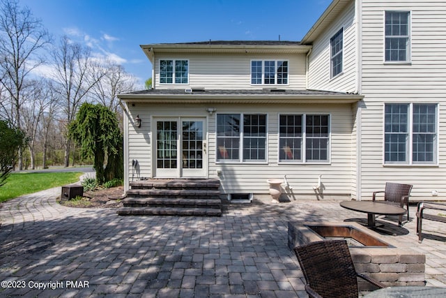 rear view of property with entry steps, a patio area, and a fire pit