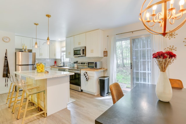 1490 Waterfront Dr, Tobyhanna, PA 18466 - kitchen featuring appliances with stainless steel finishes, decorative backsplash, and light wood-style floors
