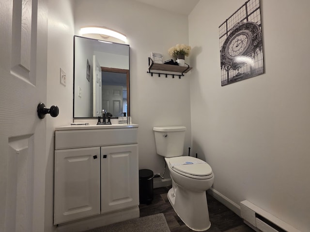 1490 Waterfront Dr, Tobyhanna, PA 18466 - bathroom with a baseboard heating unit, wood finished floors, toilet, vanity, and baseboards