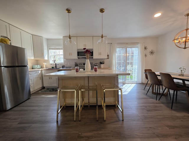 1490 Waterfront Dr, Tobyhanna, PA 18466 - kitchen featuring stainless steel appliances, a kitchen island, decorative backsplash, white cabinets, and light countertops