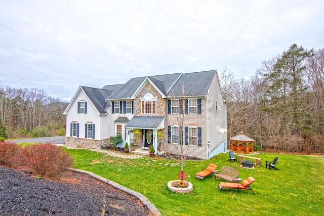 view of front facade with stone siding and a front lawn