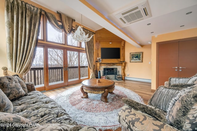 living area featuring a large fireplace, baseboard heating, wood finished floors, and beamed ceiling