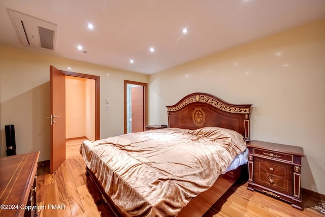 bedroom featuring baseboards, light wood-style flooring, and recessed lighting