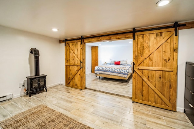 1553 Locust Ln, Pocono Lake, PA 18347 - bedroom featuring a barn door, wood finish floors, recessed lighting, and a wood stove