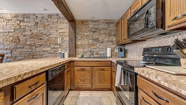 kitchen with butcher block countertops, beamed ceiling, decorative backsplash, black appliances, and a sink