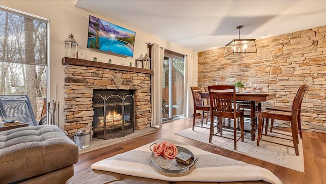 dining area with wood finished floors, a fireplace, and a chandelier