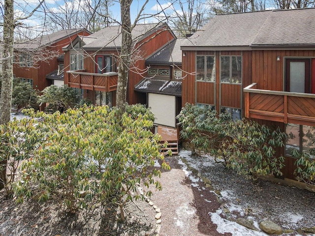 back of property with a shingled roof