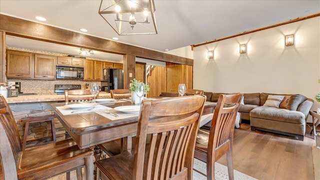 dining room featuring an inviting chandelier, recessed lighting, and wood finished floors