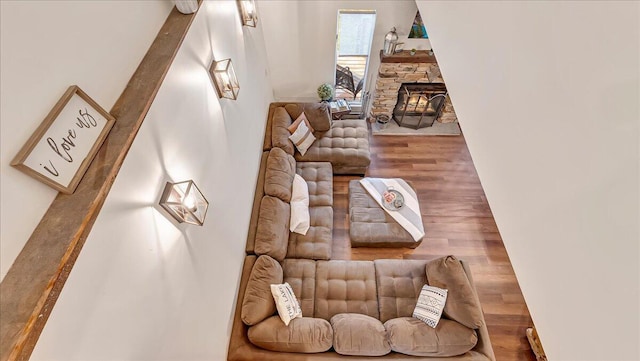 living area with a stone fireplace and wood finished floors