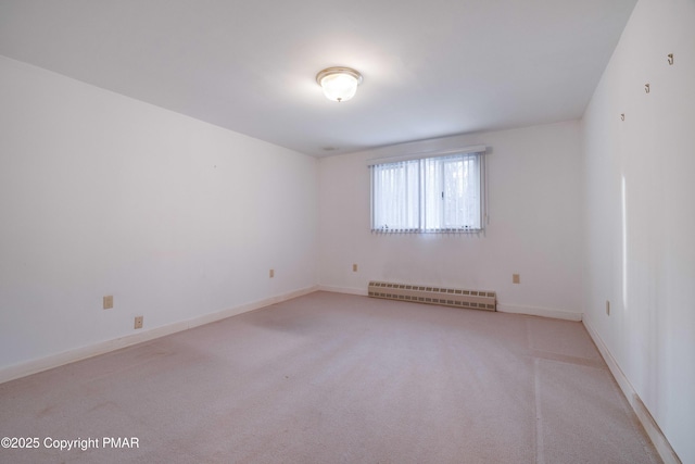 spare room featuring light colored carpet and a baseboard heating unit