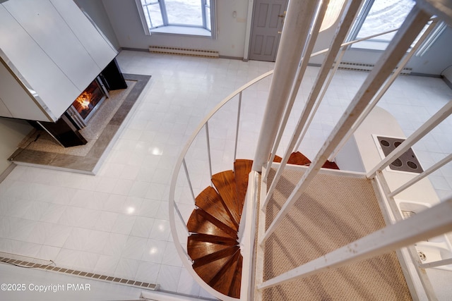 stairs with tile patterned floors and a baseboard heating unit