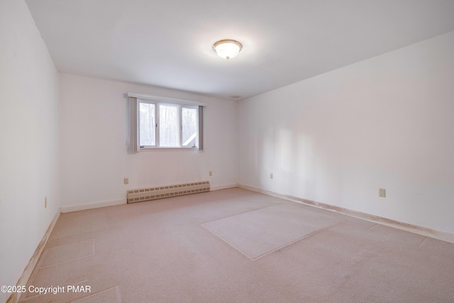 carpeted empty room featuring baseboard heating