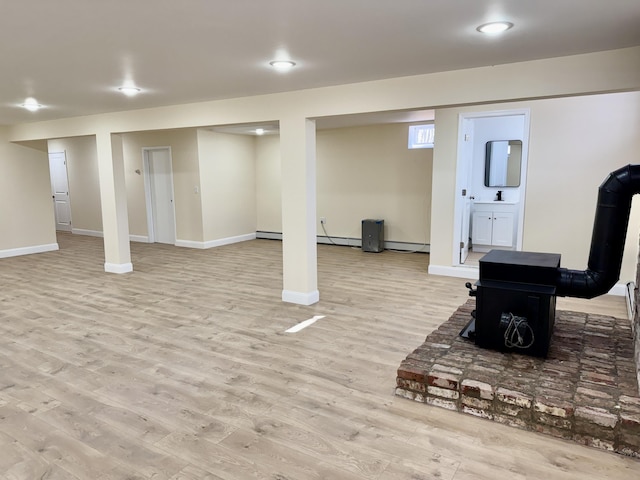 248 Seneca Dr, Milford, PA 18337 - finished below grade area with light wood-type flooring, recessed lighting, a wood stove, and a baseboard radiator