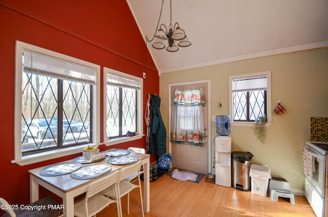 dining area featuring an inviting chandelier, vaulted ceiling, and wood finished floors