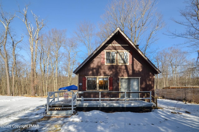 rustic home with a deck and fence