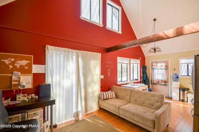 living room with high vaulted ceiling, a chandelier, and hardwood / wood-style floors