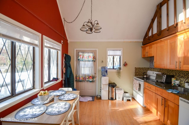 kitchen featuring lofted ceiling, white appliances, a chandelier, and decorative backsplash