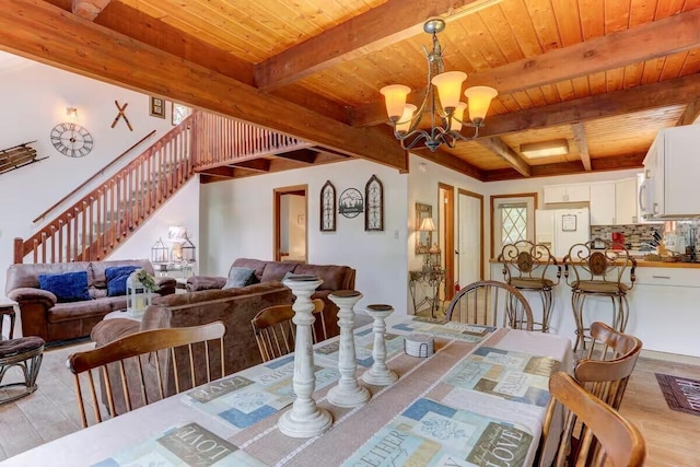 dining area with light wood finished floors, a notable chandelier, stairway, and wood ceiling