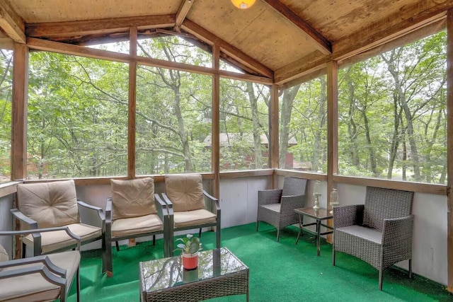 unfurnished sunroom featuring vaulted ceiling with beams