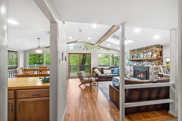 104 Jimmy Pond Ct, Pocono Pines, PA 18350 - living area with a stone fireplace, ceiling fan, healthy amount of natural light, and light wood-style floors