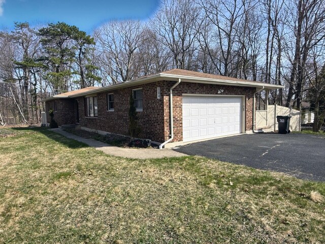 104 Sunset Dr, Mount Pocono, PA 18344 - view of side of property with a garage, driveway, brick siding, and a lawn