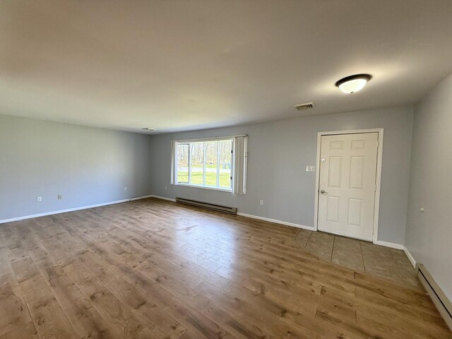 104 Sunset Dr, Mount Pocono, PA 18344 - unfurnished room featuring a baseboard radiator, wood finished floors, a baseboard heating unit, baseboards, and visible vents