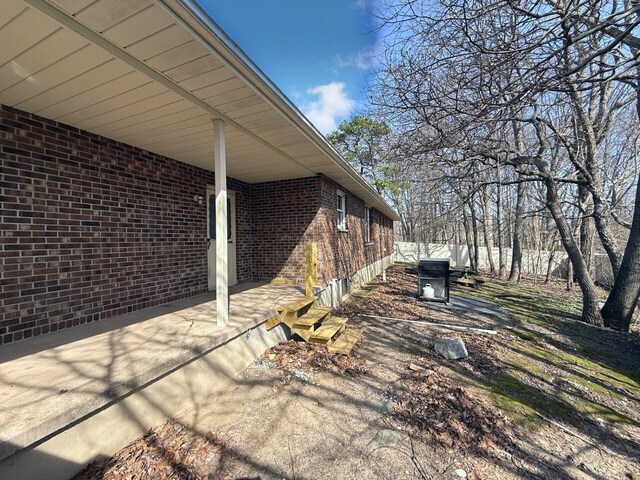 104 Sunset Dr, Mount Pocono, PA 18344 - view of side of home featuring brick siding and a patio