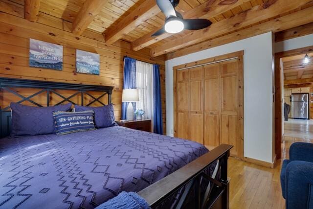 232 Stafford Dr, Bushkill, PA 18324 - bedroom featuring wood ceiling, beamed ceiling, wood-type flooring, wooden walls, and a closet