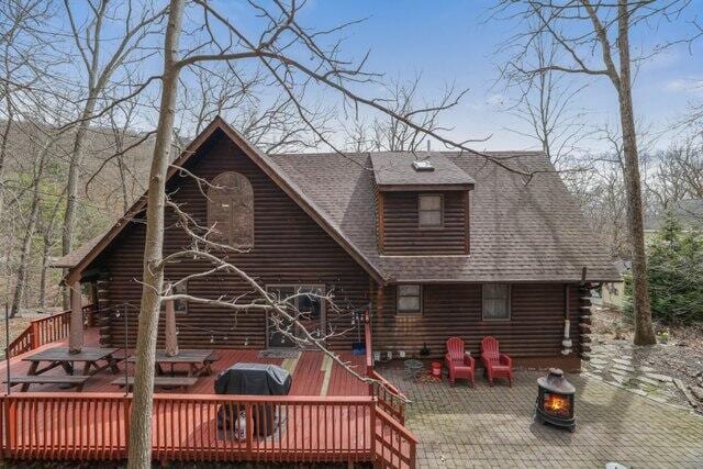 232 Stafford Dr, Bushkill, PA 18324 - rear view of property with log siding, an outdoor fire pit, a deck, a patio area, and a shingled roof