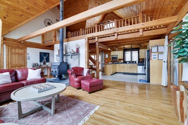 232 Stafford Dr, Bushkill, PA 18324 - living area featuring high vaulted ceiling, a wood stove, light wood-type flooring, wooden ceiling, and beam ceiling