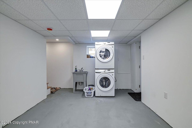 washroom featuring laundry area, a sink, and stacked washer and clothes dryer