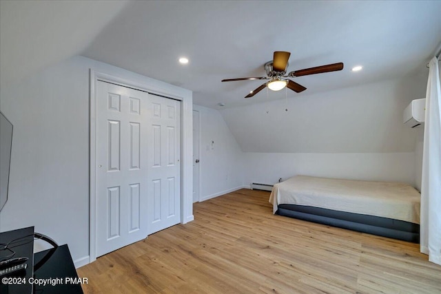 bedroom with vaulted ceiling, baseboard heating, an AC wall unit, light wood-style floors, and recessed lighting