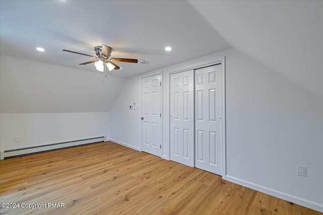 additional living space featuring lofted ceiling, wood finished floors, a ceiling fan, baseboards, and baseboard heating