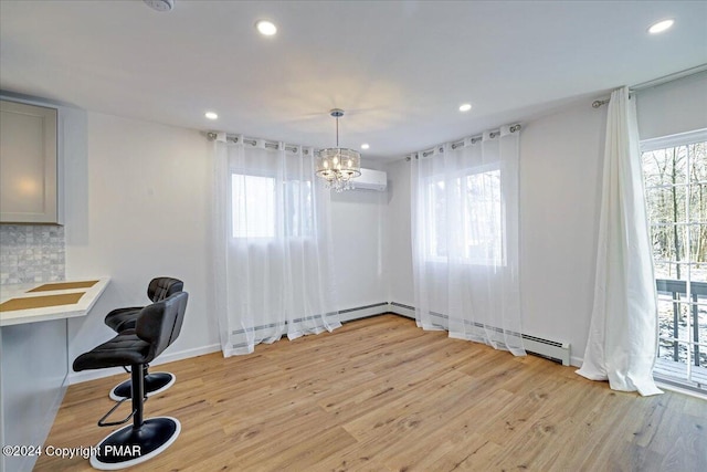 unfurnished dining area featuring baseboards, light wood-type flooring, a wall mounted AC, a notable chandelier, and recessed lighting