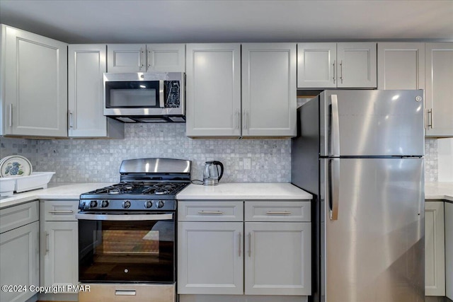 kitchen with stainless steel appliances, backsplash, and light countertops