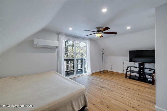 bedroom with vaulted ceiling, a wall mounted air conditioner, wood finished floors, and baseboards