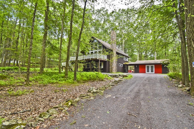 1046 Maple Dr, Pocono Lake, PA 18347 - view of front facade featuring french doors, driveway, and a chimney
