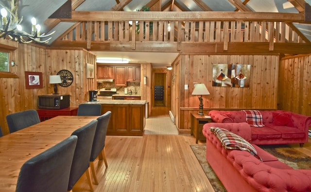 1046 Maple Dr, Pocono Lake, PA 18347 - living room with wood walls, light wood-style flooring, a chandelier, high vaulted ceiling, and beam ceiling