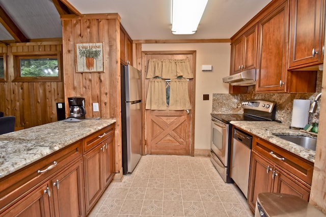 1046 Maple Dr, Pocono Lake, PA 18347 - kitchen with appliances with stainless steel finishes, under cabinet range hood, backsplash, wooden walls, and brown cabinetry