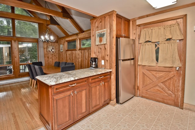 1046 Maple Dr, Pocono Lake, PA 18347 - kitchen featuring freestanding refrigerator, light stone counters, a peninsula, a chandelier, and brown cabinetry