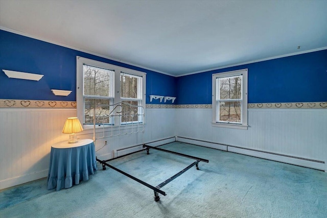 carpeted bedroom with baseboard heating, wainscoting, and crown molding