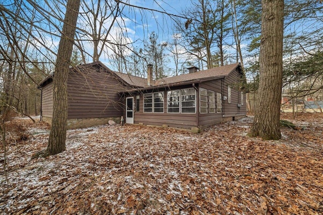 exterior space with a chimney and a sunroom