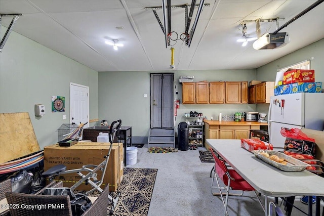 garage featuring freestanding refrigerator and a garage door opener