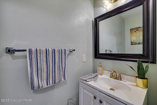 bathroom with a textured wall and vanity