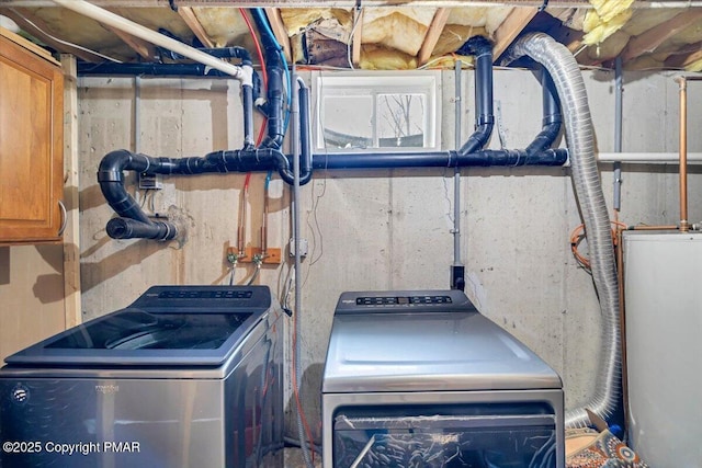 clothes washing area featuring water heater and washing machine and clothes dryer