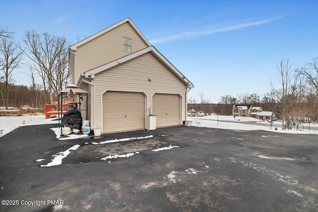 snow covered garage with driveway