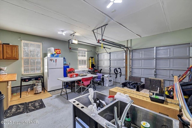 garage with a garage door opener and freestanding refrigerator