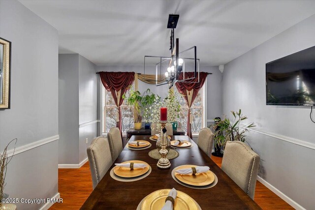 dining room with hardwood / wood-style flooring and a notable chandelier