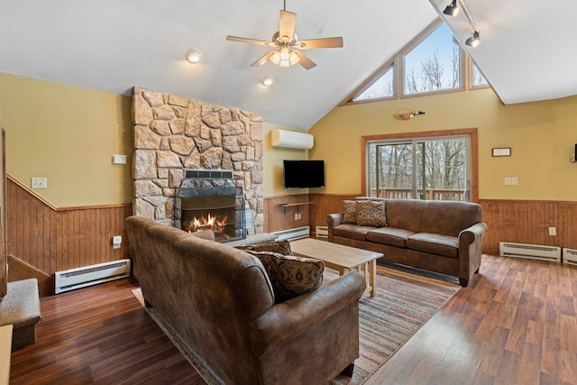 living area with a wainscoted wall, an AC wall unit, wood walls, a fireplace, and a baseboard heating unit